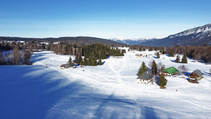 Panoramic view of snowy mountains in winter. Foggy mountains. Woods in front of the mountains. Mountains resort station.