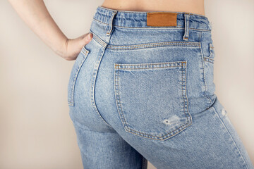 Woman in blue jeans rear view. Female buttocks in jeans on a white background.