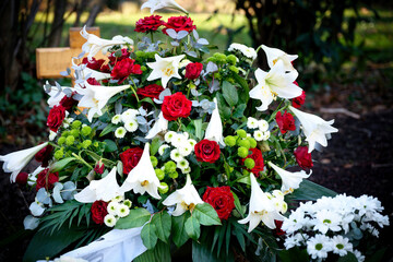 red roses and white lilies on a grave after a funeral