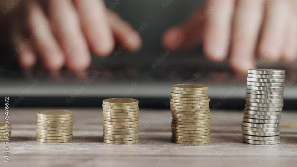 Poster the trader's hands are typing on the keyboard against the background of stacks of coins. the concept