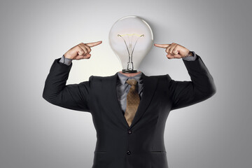 Hombre trajeado con las manos apuntando hacia su cabeza de lámpara 