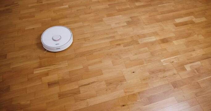 Robot vacuum cleaner performs automatic cleaning of the house at a certain time. Smart home concept. Copy space