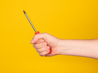 Hand holding a screwdriver. No face, yellow background.
