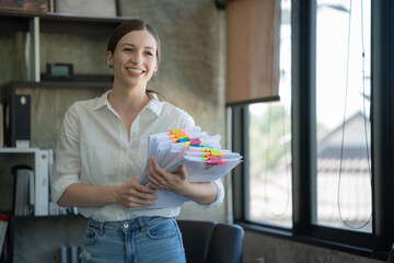 Young female officer holding a pile of paperwork.