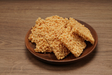 A plate of crispy rice is on the wooden table
