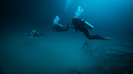 technical divers diving above a halocline in Angelita cenote