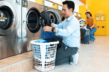 Asian people using qualified coin operated laundry machine in the public room to wash their cloths....