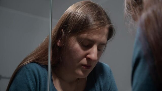 Reflection in mirror of upset woman suffering from problems in life. Concept of depression, stress, mental illness and problems, loneliness and frustration