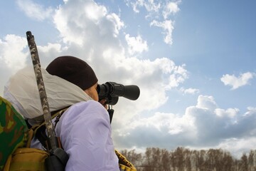 Naklejka na ściany i meble A shallow focus shot of a soldier looking through binoculars