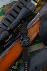 Close up black analog-digital hybrid wristwatch. Military style men watch with military objects.