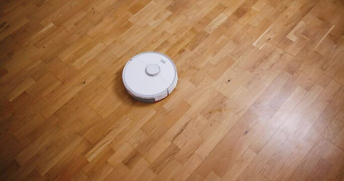 Robot vacuum cleaner performs automatic cleaning of the house at a certain time. Smart home concept. Copy space
