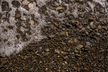 Sea pebbles and an incoming sea wave on the Black Sea coast of the Krasnodar Territory resort on a...