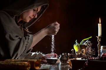young medieval herbalist sprinkles salt