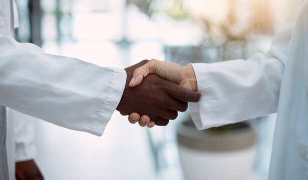 Doctor, handshake and partnership in healthcare, agreement or deal for collaboration, teamwork or unity. Hand of medical professionals shaking hands for meeting, greeting or success in solidarity - Powered by Adobe