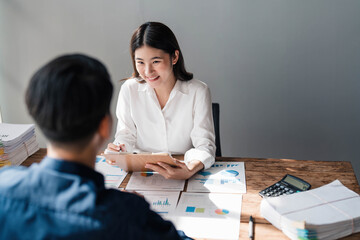 Two business people talk project strategy at office meeting room. Businessman discuss project planning with colleague at modern workplace while having conversation and advice on financial data report.