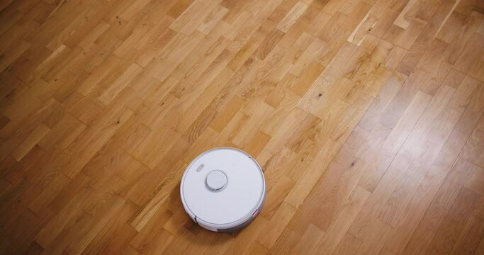 Robot vacuum cleaner performs automatic cleaning of the house at a certain time. Smart home concept. Copy space