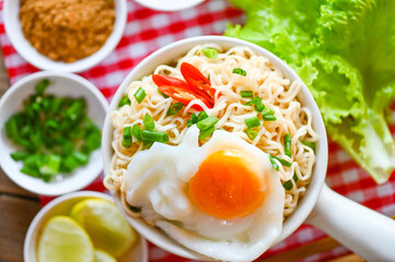 noodles bowl with boiled egg vegetable spring onion lemon lime lettuce celery and chili on table food , instant noodles cooking tasty eating with bowl noodle soup - top view