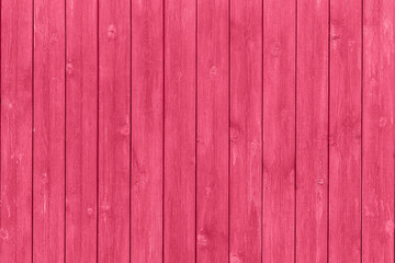 Trendy color of the year 2023. Wooden planks boards, vertical pattern, toned in viva magenta color...