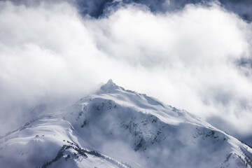Fototapeta na wymiar Snow and Cloud covered Canadian Nature Mountain Landscape Background. Winter Season in Whistler, British Columbia, Canada.