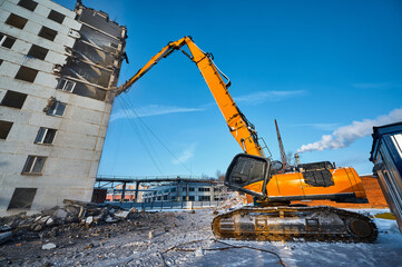 Destruction of old factory building with excavator destroyer