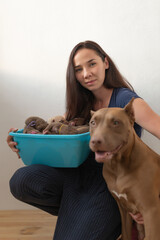 Portrait of a young beautiful dark-haired girl, a breeder of pit bull terriers with puppies.