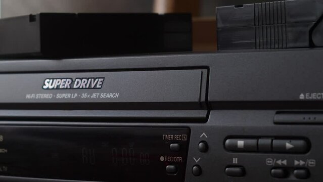 close-up of a video cassette with the inscription birthday is loaded into a vintage video player. selective focus. archival home family footage