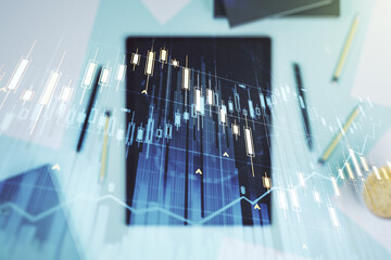 Multi exposure of abstract creative financial graph and modern digital tablet on background, top view, forex and investment concept
