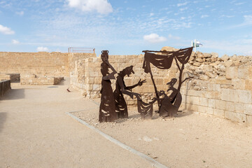 Abstract figure of seller and buyers made of iron near ruins of city - fortress of Nabateans Avdat,...