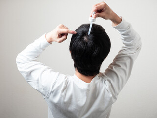 Naklejka premium 育毛剤を塗る男性 後頭部 髪の毛