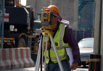 Construction level, surveyor engineer with equipment (theodolite or total station) at the...