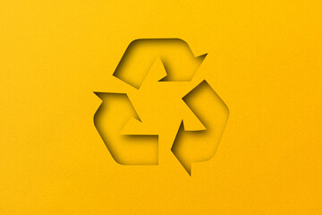 Yellow paper punched cut into recycled shapes isolated on yellow paper background.