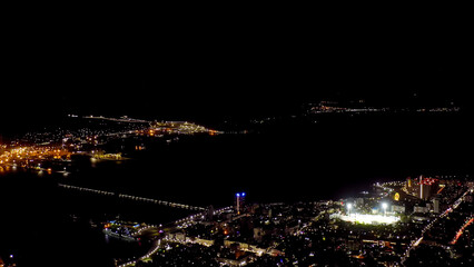 Fototapeta na wymiar Novorossiysk, Russia. Port of Novorossiysk at night. Night city lights. Tsemesskaya Bay in the Black Sea, Aerial View