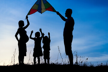 Happy family playing on nature summer silhouette