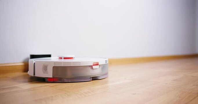 Robot vacuum cleaner performs automatic cleaning of the house at a certain time. Smart home concept. Copy space