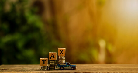 Tax Concept with wooden block on stacked coins .graphs,  income tax return form online for tax...