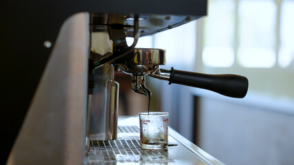 Closeup coffee machine that distilling coffee water from grounds make coffee water, small glass placed under maker, support concentrated coffee extraction, before making various menus.