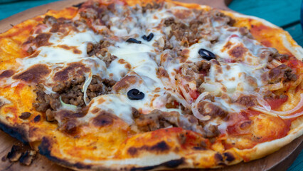 close up of homemade pizza with mozarella and meats