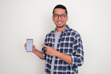 Adult Asian man smiling and pointing to blank mobile phone screen that he hold