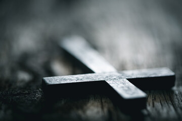 A wooden Christian cross crucifix on a grunge board background. Wooden Christian cross on grey...