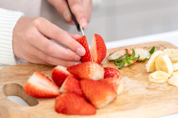 クレープ作りでいちごをカットする女の子の手元