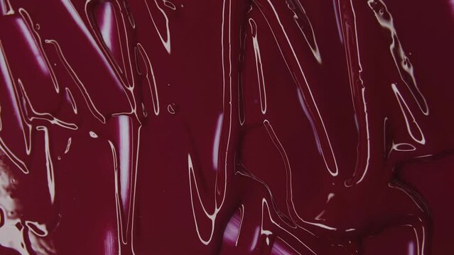 Red lipstick. Red background. Light and shine. Thick liquid. Smears of paint. Divorces on canvas. Decorative cosmetics. Вeauty salon advertisement. Wallpaper.
