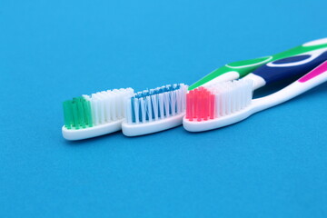 Three different toothbrushes lie on a blue background.