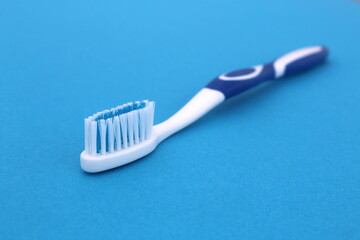 On a blue background lies a new toothbrush.