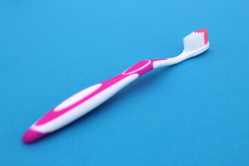 On a blue background lies a new toothbrush.