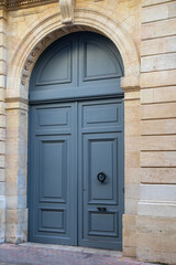 Fototapeta na wymiar grey wooden high big arch door of street restored house entrance facade classic gate in city