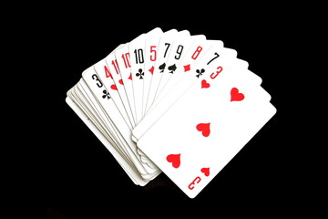 Playing cards lie on a black isolated background.