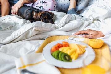 Obraz na płótnie Canvas family of women having breakfast on bed and dog pet at home in Latin America