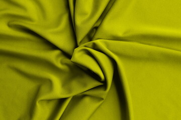  Thin bright knitted fabric lies twisted, top view.