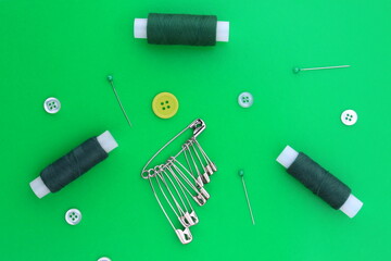 Sewing accessories lie on a green background.