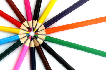 Bright multi-colored pencils lie on a white isolated background.